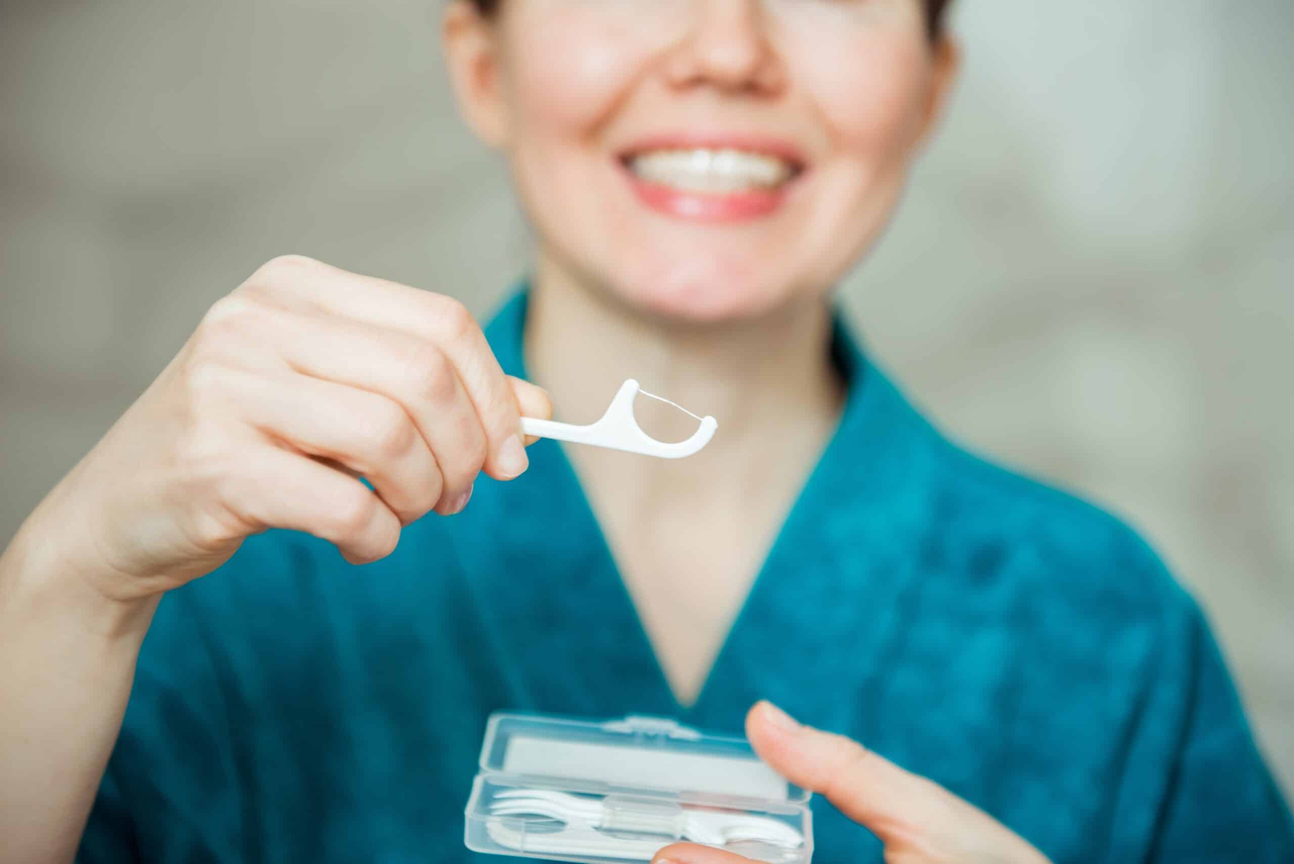 Woman,Holding,Dental,Floss,Picks,,Close,Up